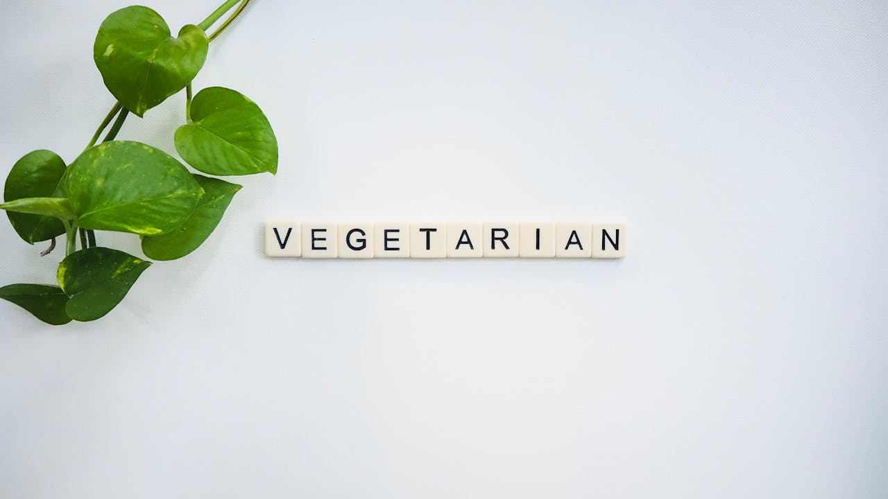 A simple and fresh vegetarian concept featuring green leaves and tiles spelling VEGETARIAN.